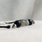 Gros plan sur un bracelet artisanal en pierres de lave et labradorite de 6 mm, monté sur cordon noir avec détails en acier inoxydable.