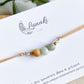 Gros plan du bracelet cordon personnalisable Gardien des Souvenirs en acier doré, montrant les détails des pierres et des billes en acier inoxydable.