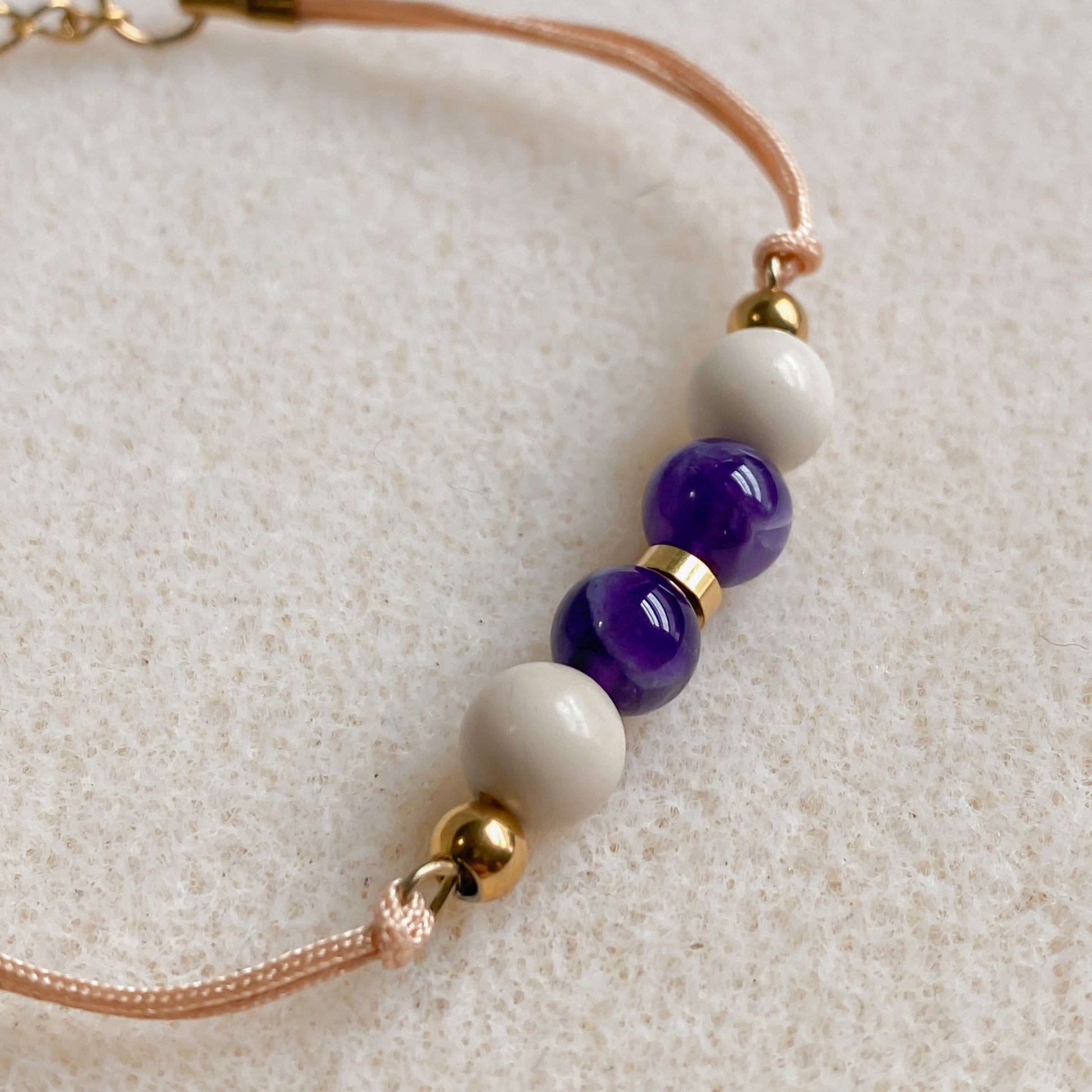 Bracelet artisanal Zéphyr en améthyste et pierre de rivière, cordon champagne et finitions dorées
