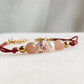 Gros plan sur les perles du bracelet Éveil, cordon rouge en pierres naturelles avec pierre de soleil, perle d’eau douce et perle en céramique décorée.