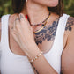 Femme portant le bracelet fin en pierres de jade jaune et perles d’eau douce, bijou doré ajustable Lunaki.