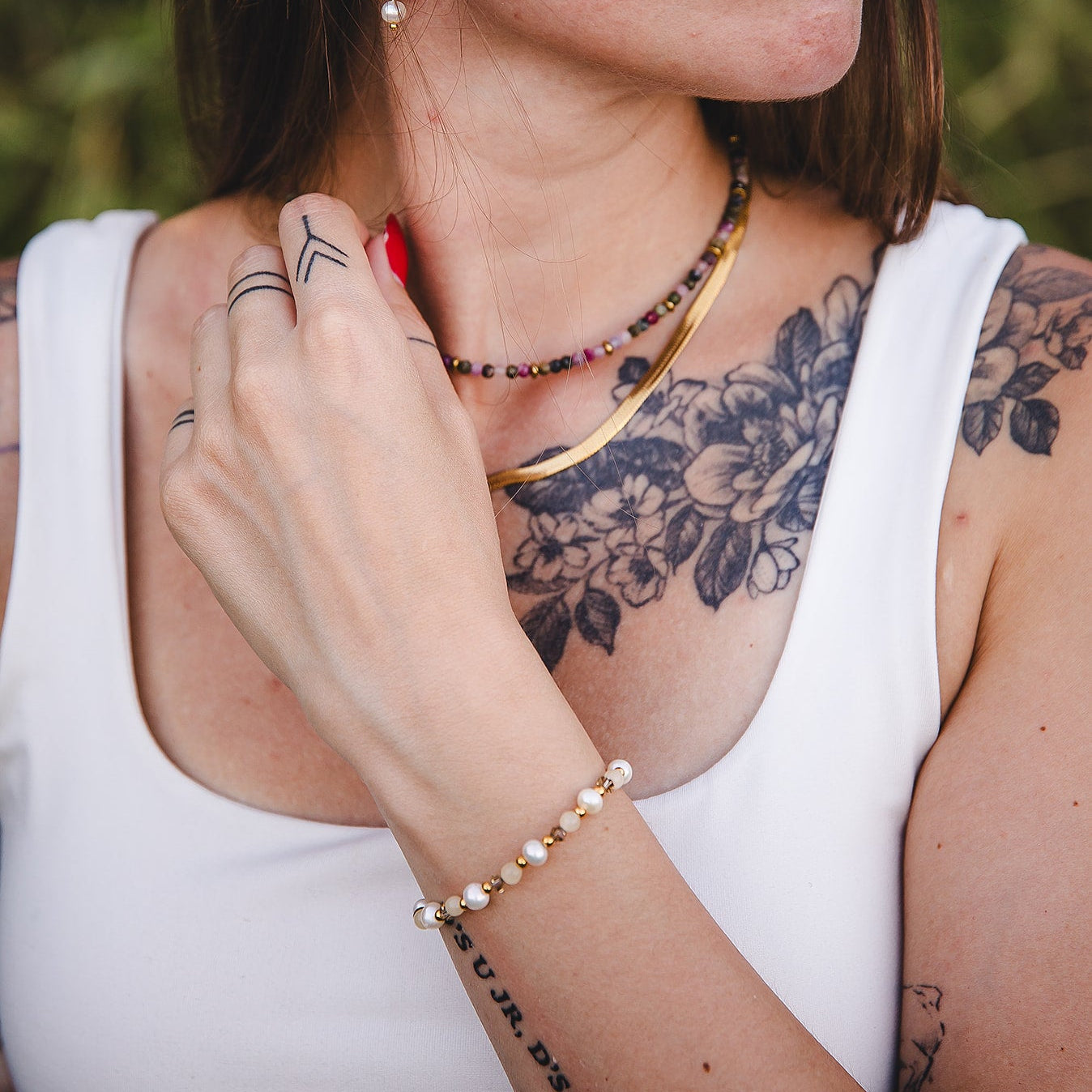 Femme portant le bracelet fin en pierres de jade jaune et perles d’eau douce, bijou doré ajustable Lunaki.