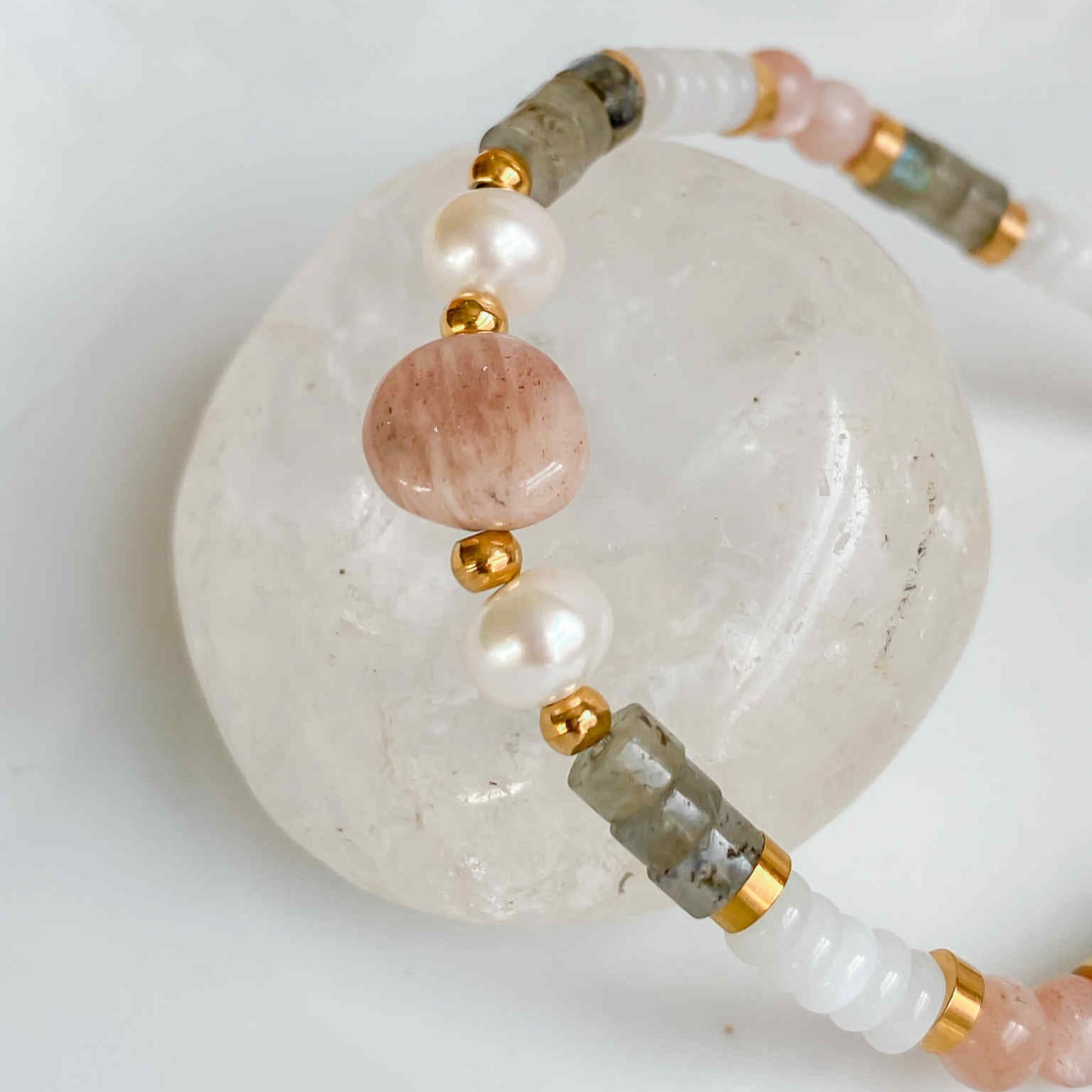 Gros plan sur la pierre de soleil et la perle d’eau douce du bracelet Hécate, bijou en pierres naturelles.
