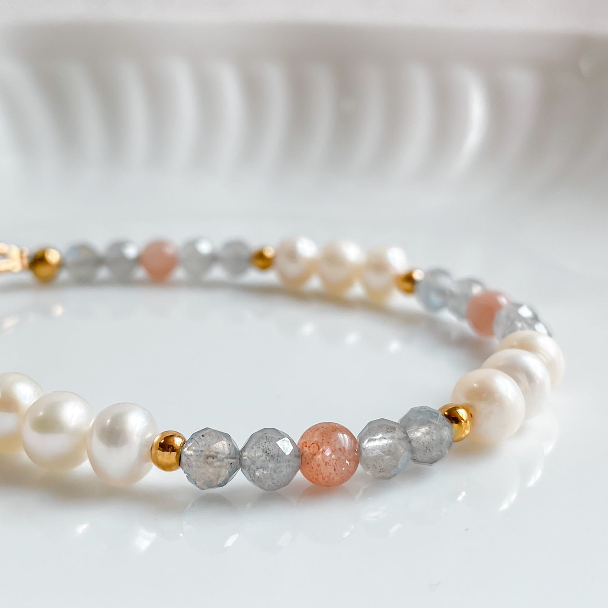 Gros plan sur les perles d’eau douce et la labradorite facettée du bracelet Nérida.