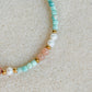Gros plan sur l’amazonite, la pierre de soleil et les perles d’eau douce du bracelet Riad