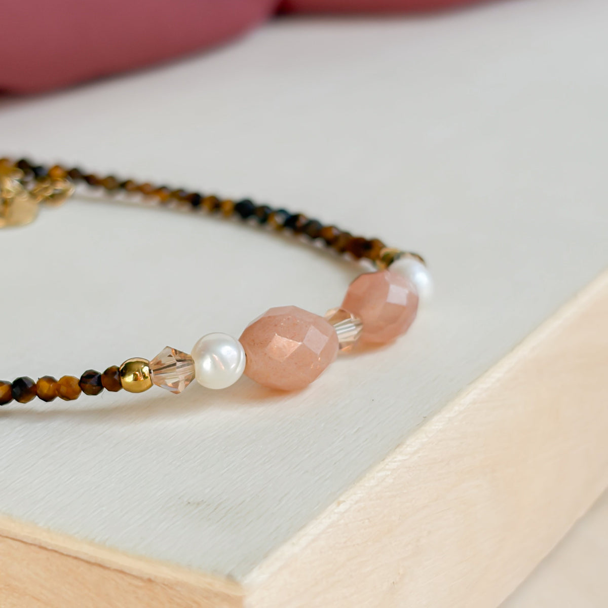 Gros plan sur les pierres de soleil et la perle d’eau douce du bracelet Terra