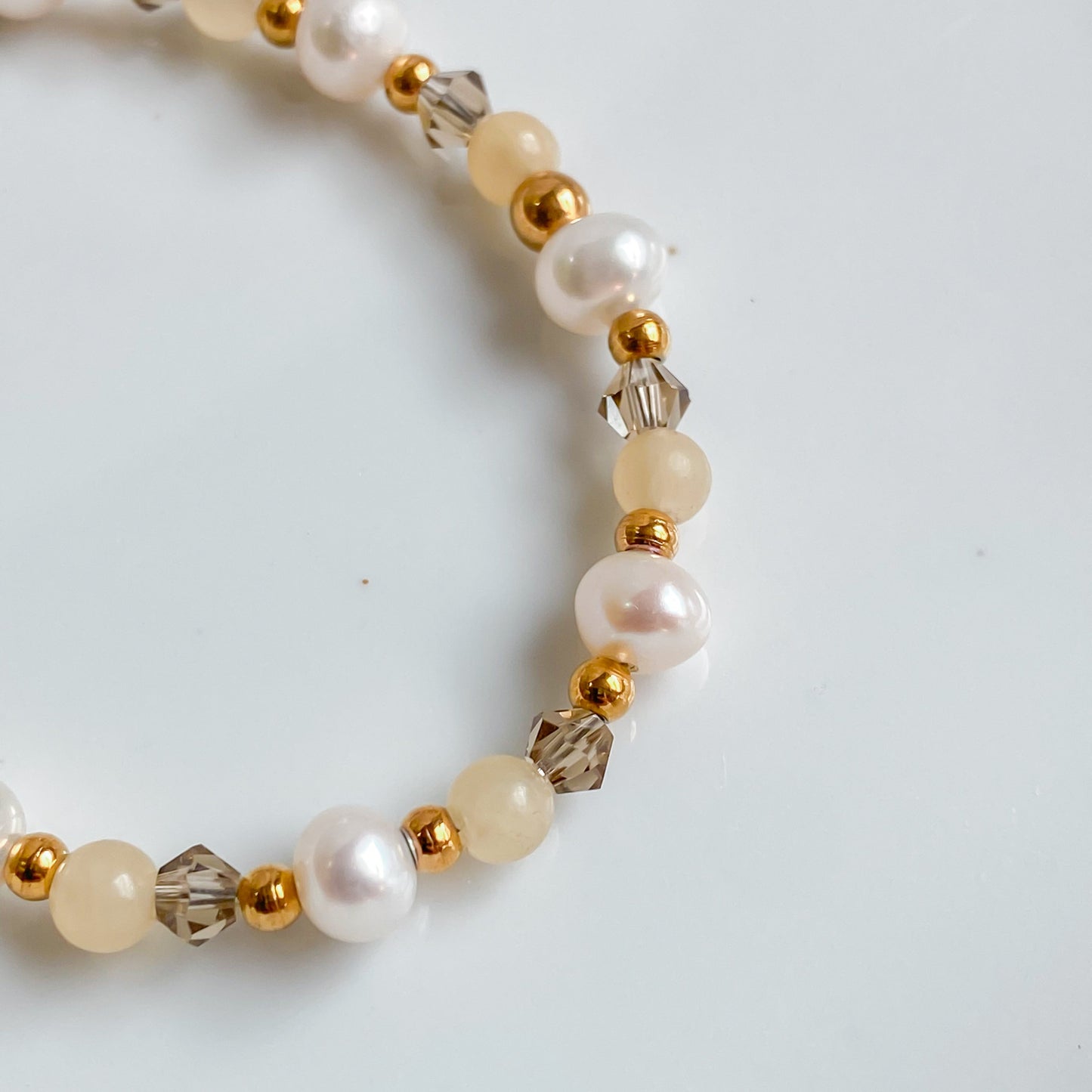 Bracelet doré Théia composé de jade jaune, perles d’eau douce et cristaux fumés, création artisanale Lunaki.