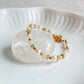 Bracelet fin Théia avec pierres de jade jaune et perles d’eau douce, monté sur acier inoxydable doré.