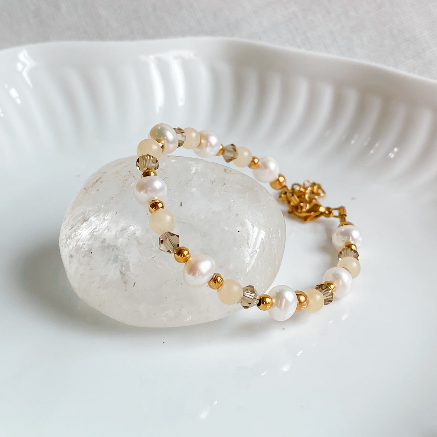 Bracelet fin Théia avec pierres de jade jaune et perles d’eau douce, monté sur acier inoxydable doré.