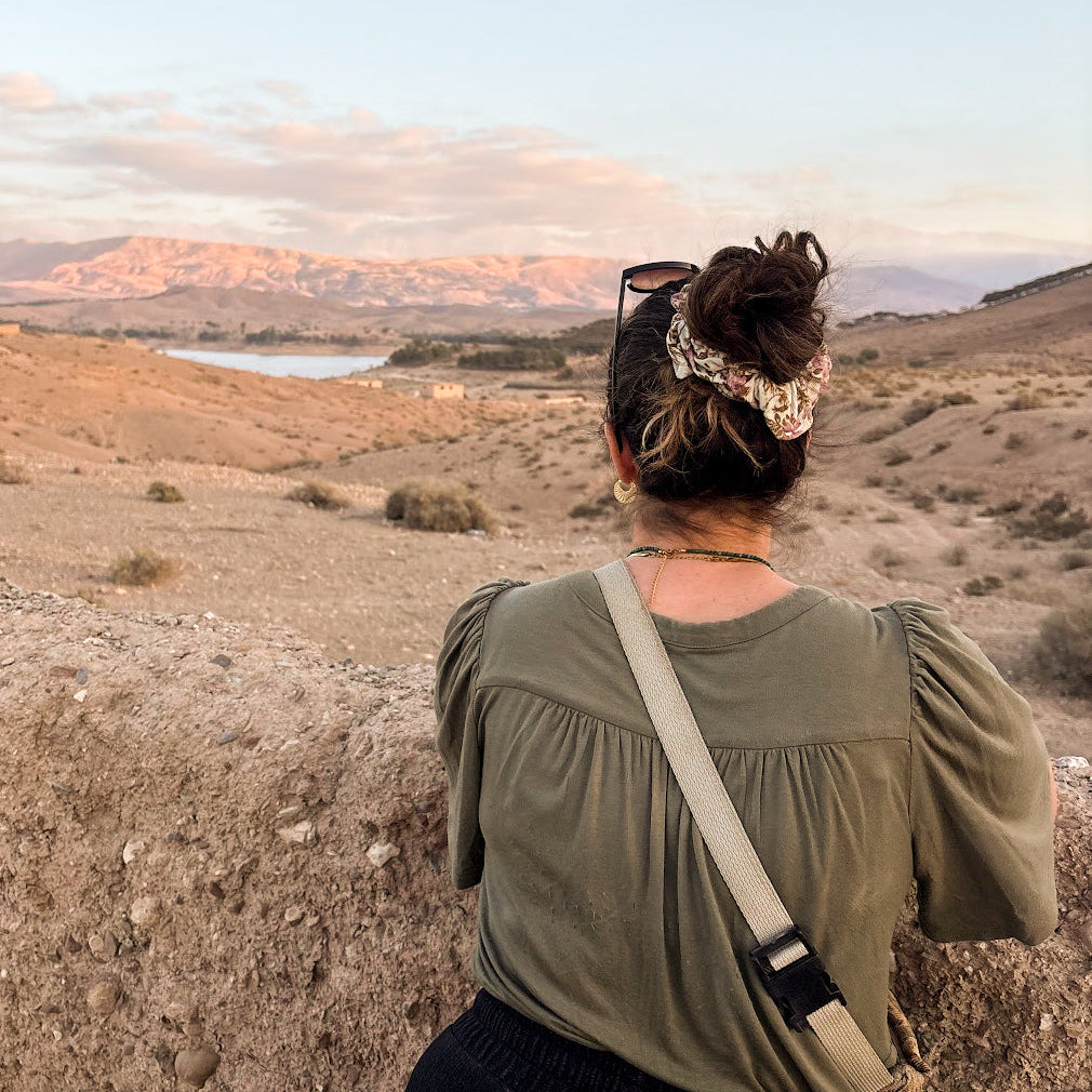Alexia, créatrice de Lunaki, contemplant les montagnes de l’Atlas au coucher du soleil au Maroc.