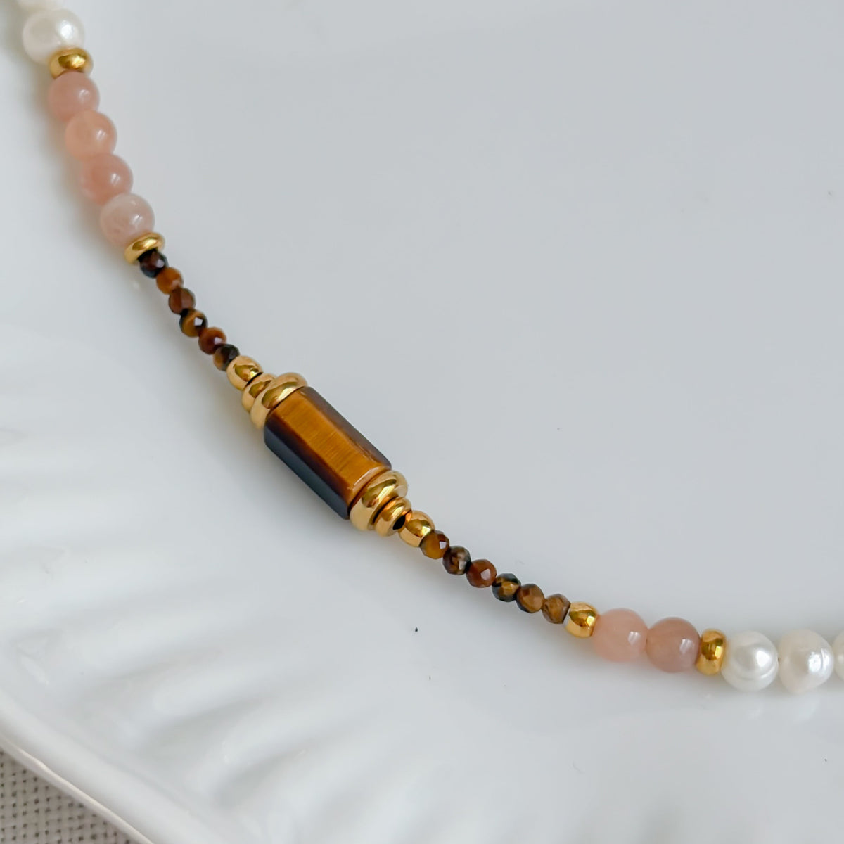Gros plan sur une pierre rectangulaire en œil de tigre du collier Agafay