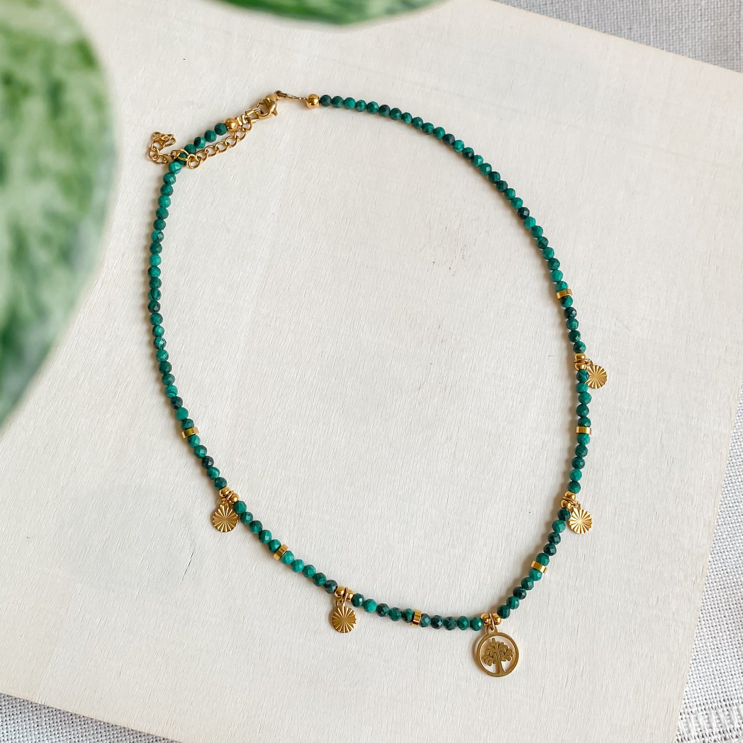 Vue du collier Déméter en pierres facettées de malachite et pendentif arbre de vie doré, bijou talisman de la collection Jardin Secret.
