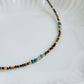 Détail des perles bleues d’apatite et brunes d’œil de tigre du collier Atlas
