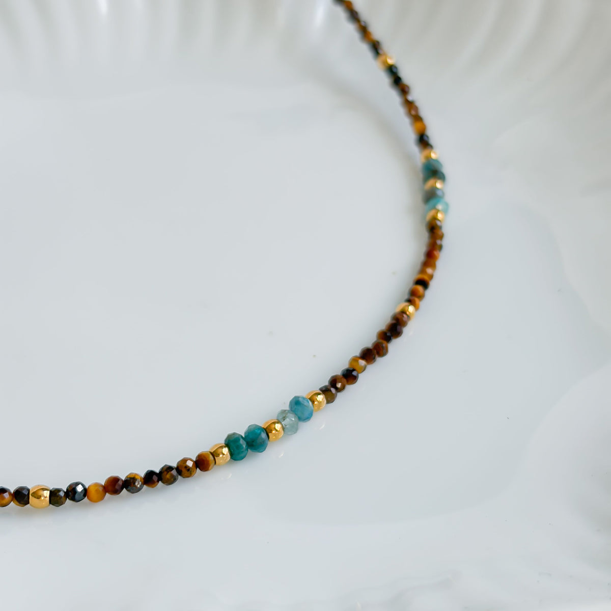 Détail des perles bleues d’apatite et brunes d’œil de tigre du collier Atlas