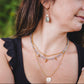 Collier Aurora en acier inoxydable doré 18K porté avec un collier de labradorite et un pendentif rond, superposition tendance.