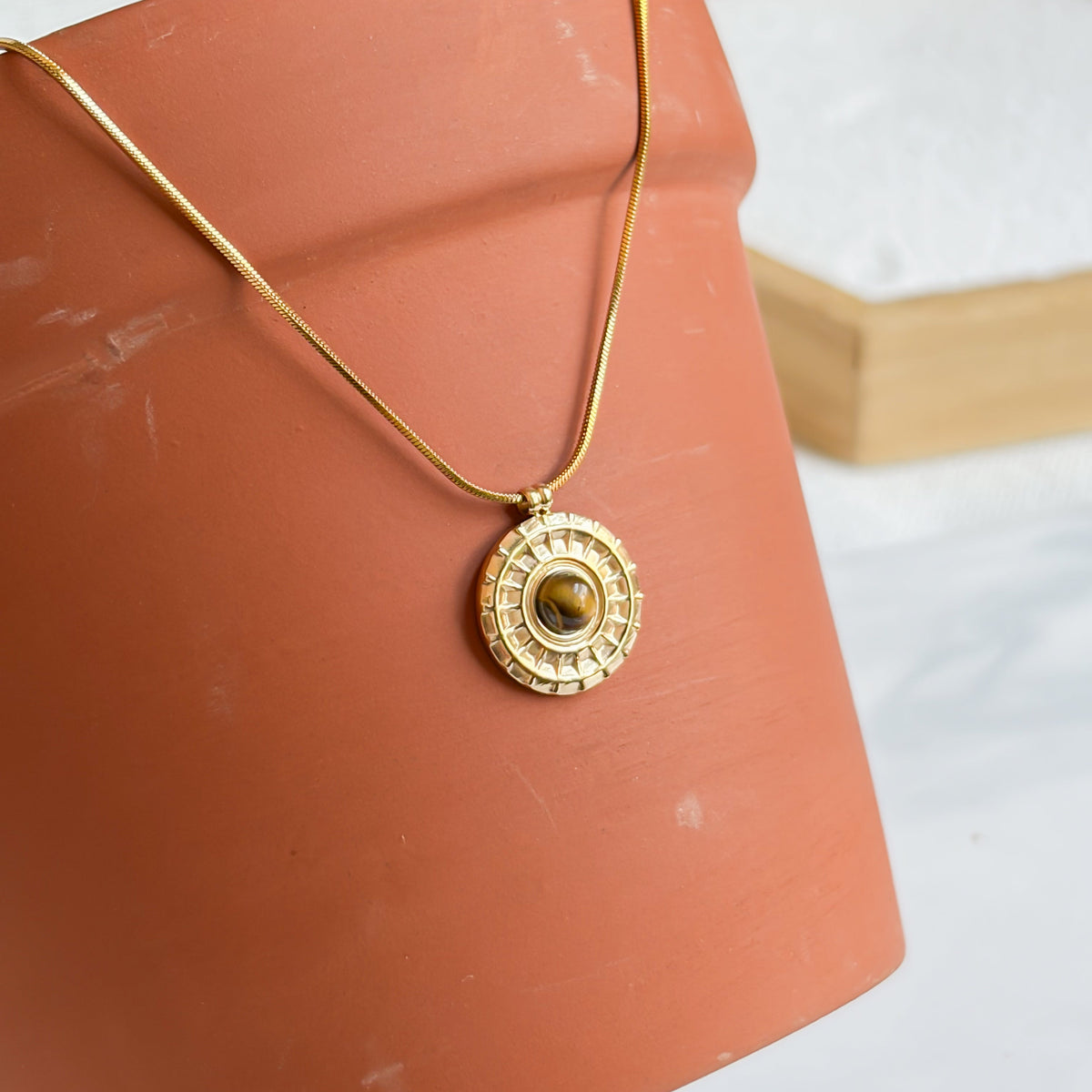 Collier Bahia en œil de tigre présenté sur un décor terracotta