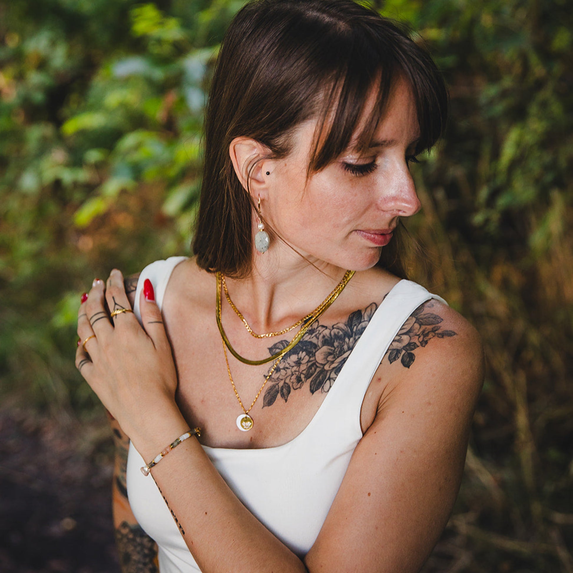 Femme portant le collier ras de cou doré Cléopâtre en superposition avec d’autres colliers en acier inoxydable 18K