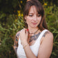 Femme portant le collier Iris en tourmaline naturelle et hématite dorée avec d’autres bijoux Lunaki, création artisanale de la collection Jardin Secret à Montréal.