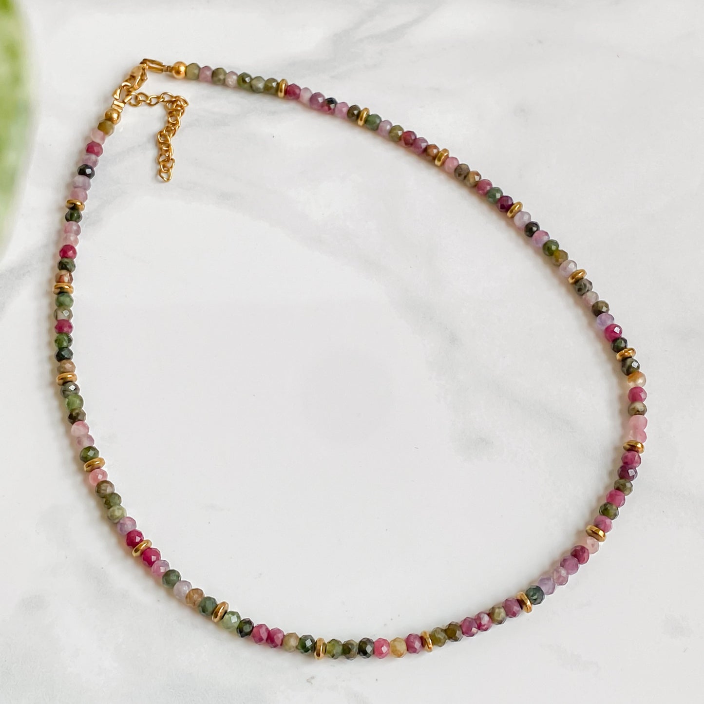 Collier Iris en tourmaline naturelle et hématite dorée sur chaîne en acier inoxydable doré 18K, collection Jardin Secret Lunaki.Collier Iris en tourmaline naturelle et hématite dorée sur chaîne en acier inoxydable doré 18K, collection Jardin Secret Lunaki.