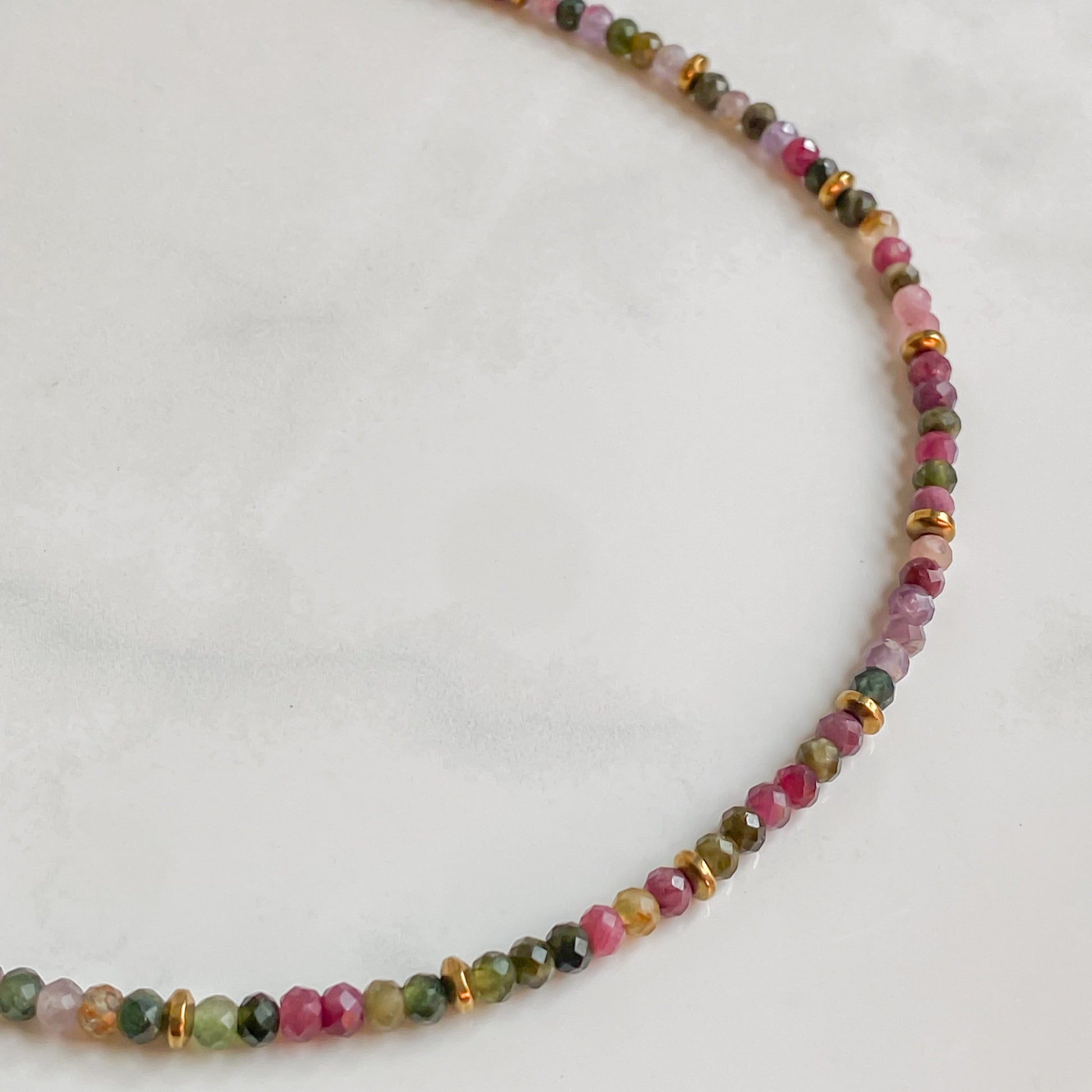 Collier Iris en tourmaline naturelle aux nuances vertes, roses et orangées, avec détails dorés en hématite.