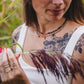 Femme portant le collier Iris en tourmaline naturelle et hématite dorée superposé à un autre collier, bijou artisanal de la collection Jardin Secret Lunaki.