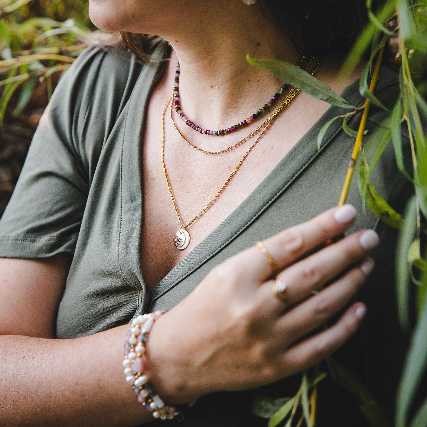 Collier en nacre et fleur de lotus dore Thetis porte par une femme en exterieur