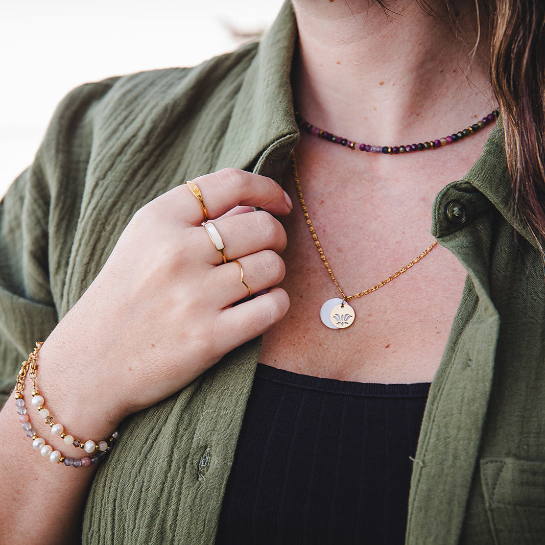 Collier en nacre et fleur de lotus dore superpose avec dautres bijoux Lunaki