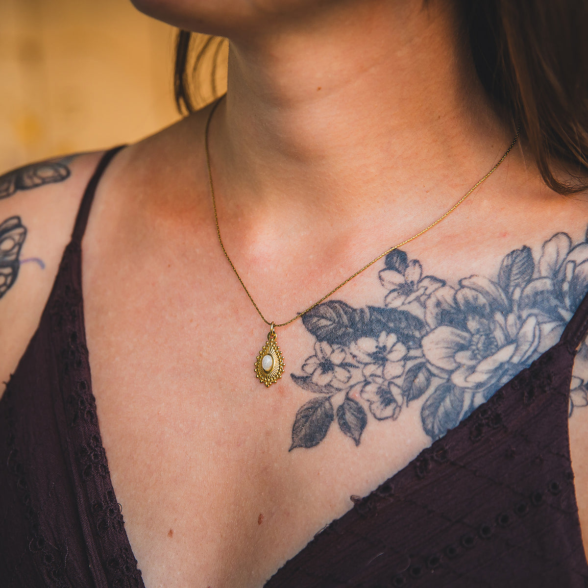 Gros plan du collier Noor doré en labradorite porté