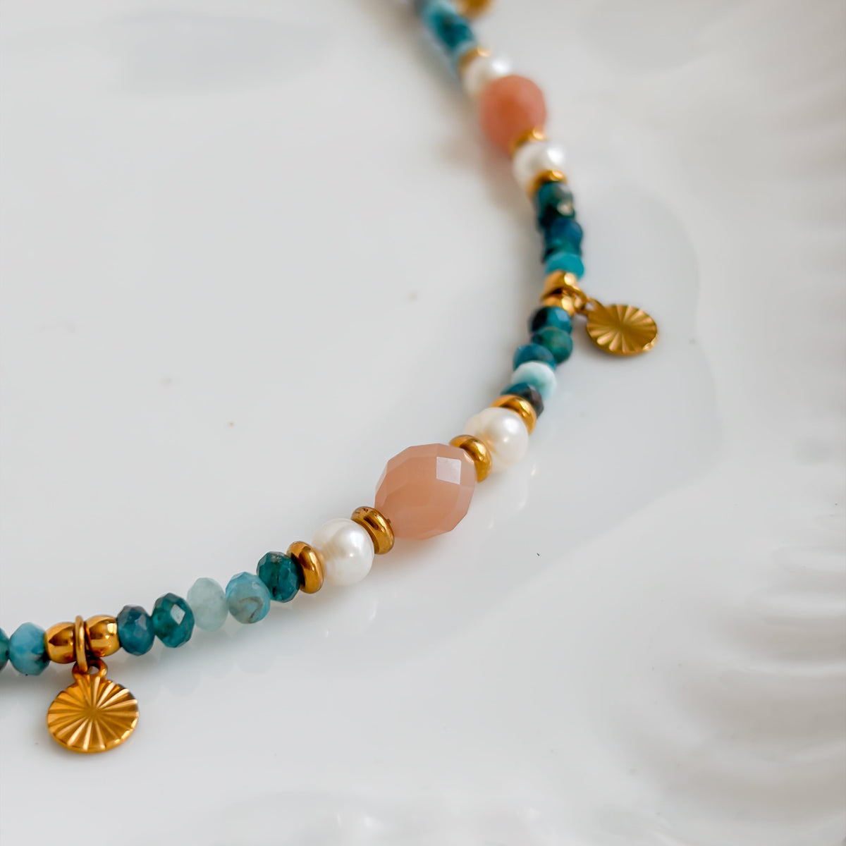 Gros plan sur l’apatite, la pierre de soleil et les perles d’eau douce du collier Oasis