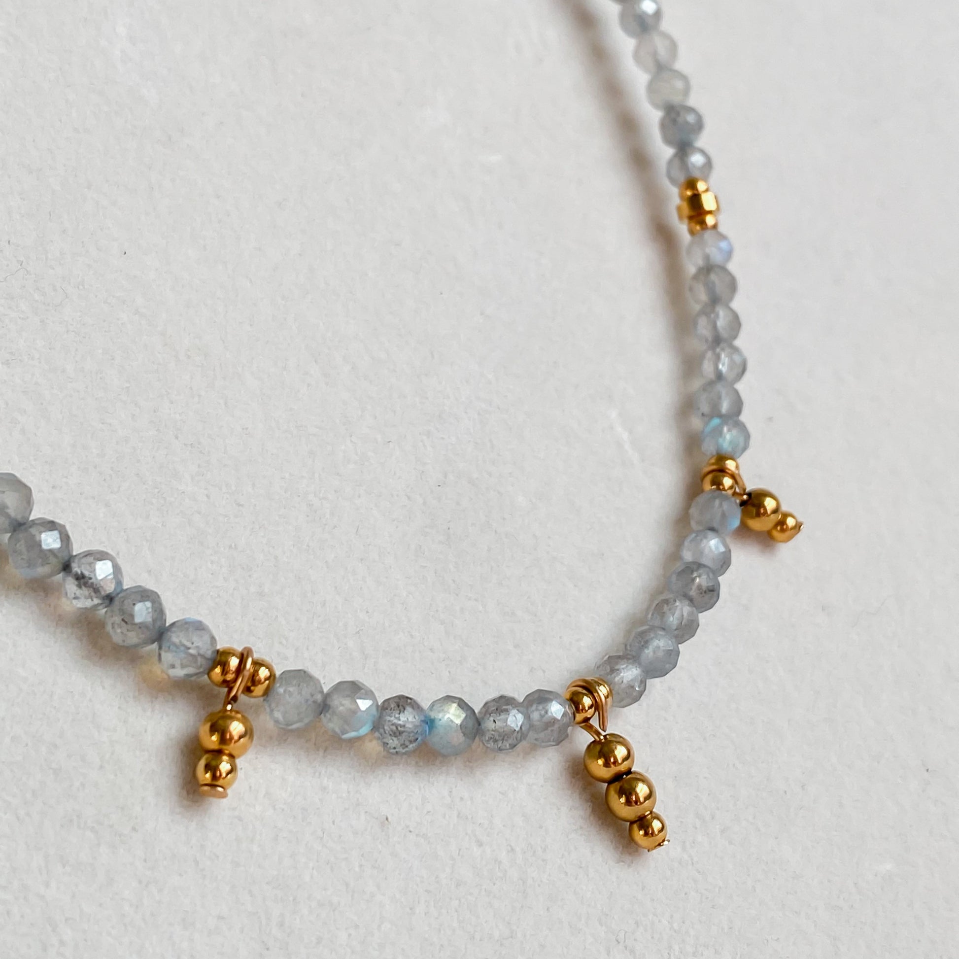 Détail du collier en pierres de labradorite avec billes dorées plaqué or 18K