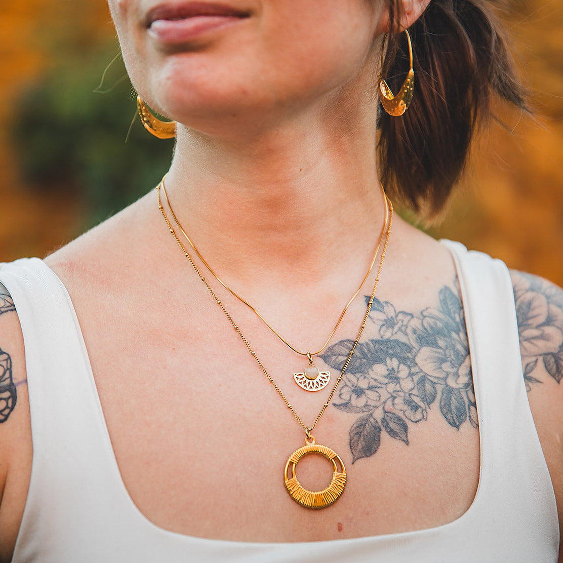 Collier Rosace doré porté en accumulation avec le collier Escale