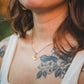 Gros plan du collier Rosace doré en quartz rose porté