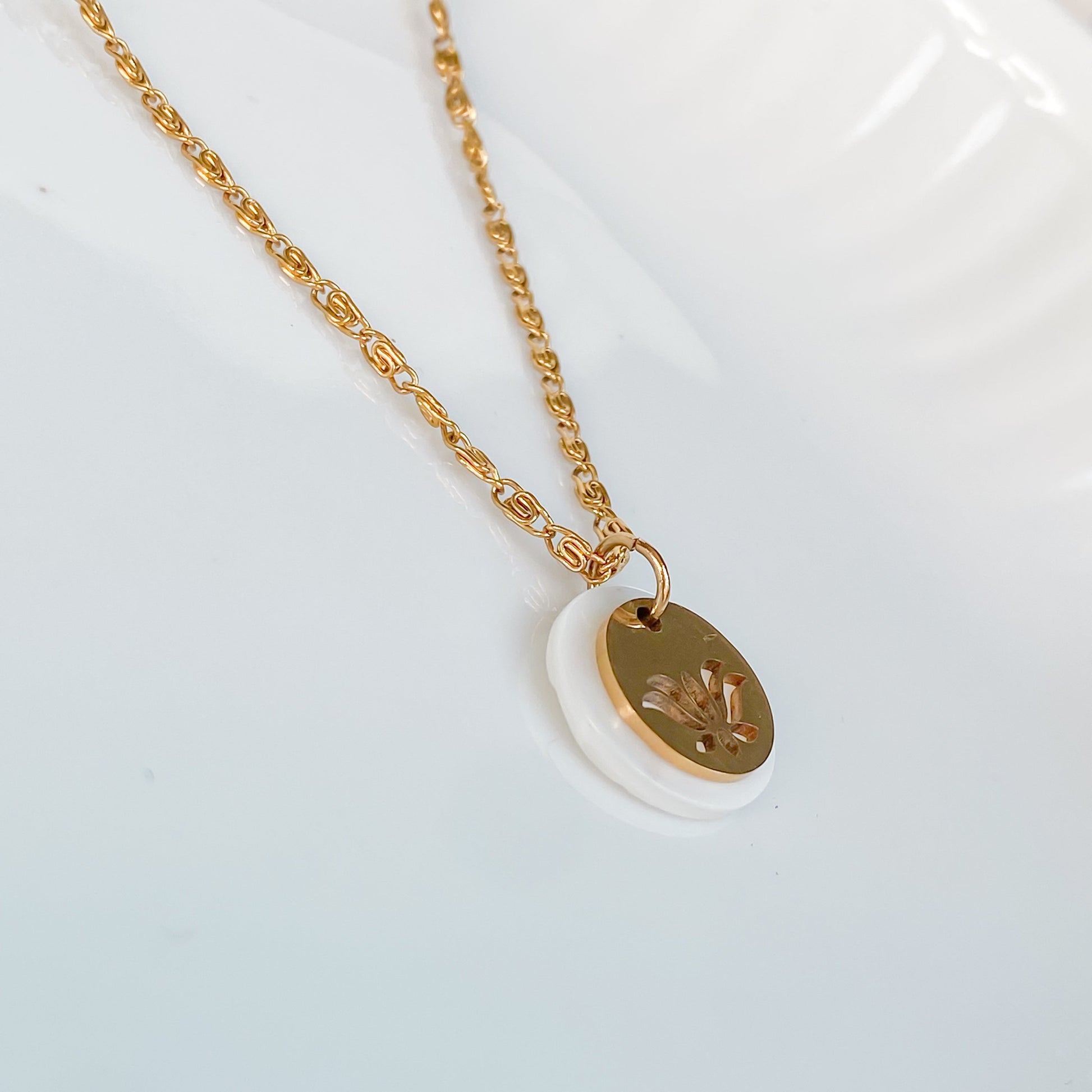 Detail du pendentif fleur de lotus dore et nacre du collier Thetis