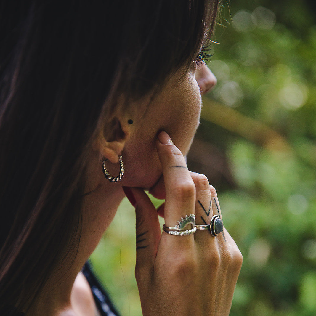 Femme portant les créoles texturées en argent 925 Héra dans un style naturel