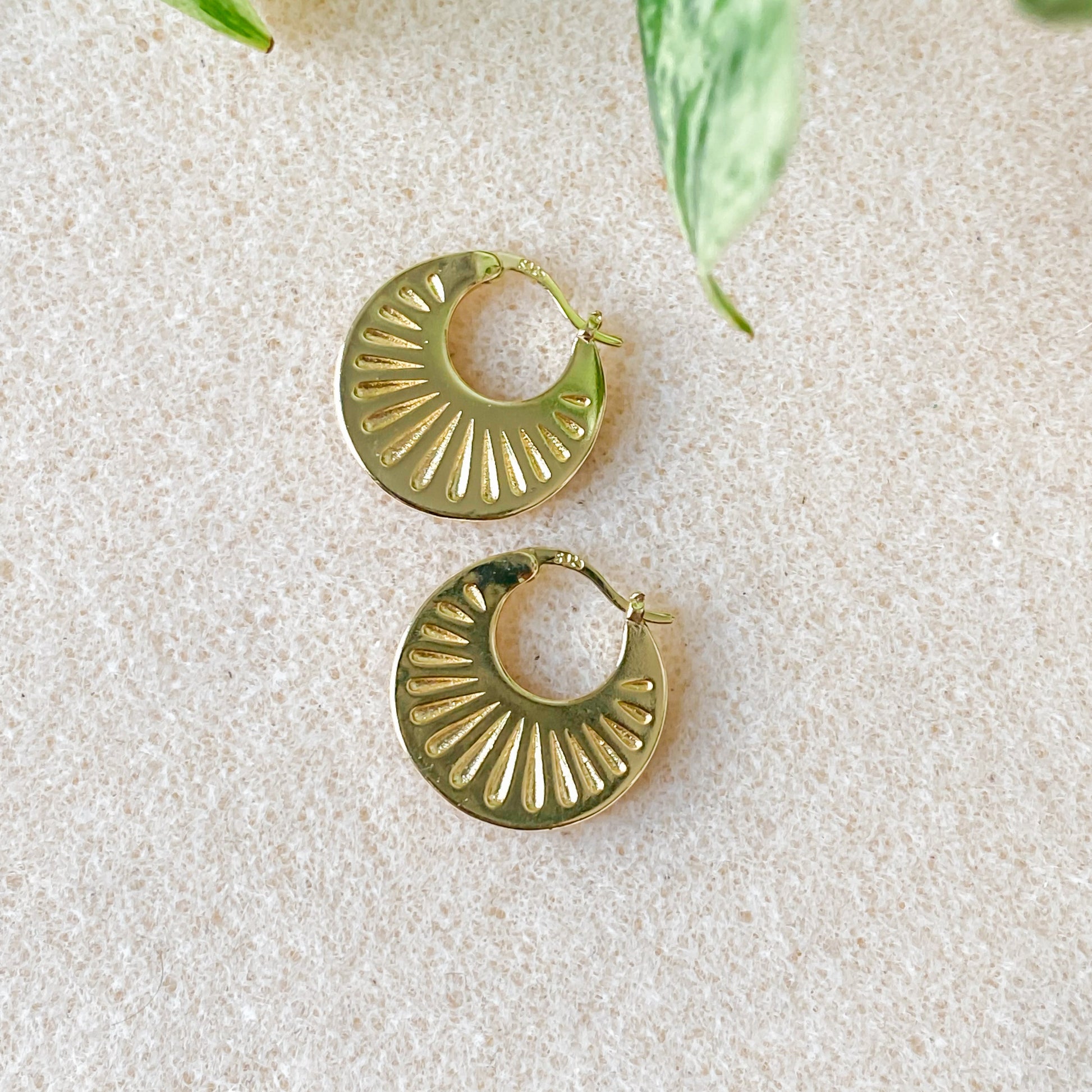Boucles d’oreilles Hélia créoles texturées en plaqué or 18K avec finition lumineuse.