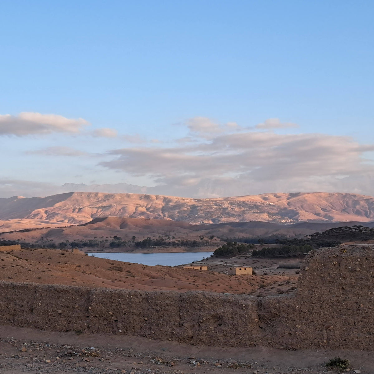 Paysage du désert d’Agafay au Maroc avec ses collines rocheuses baignées par la lumière de fin de journée.