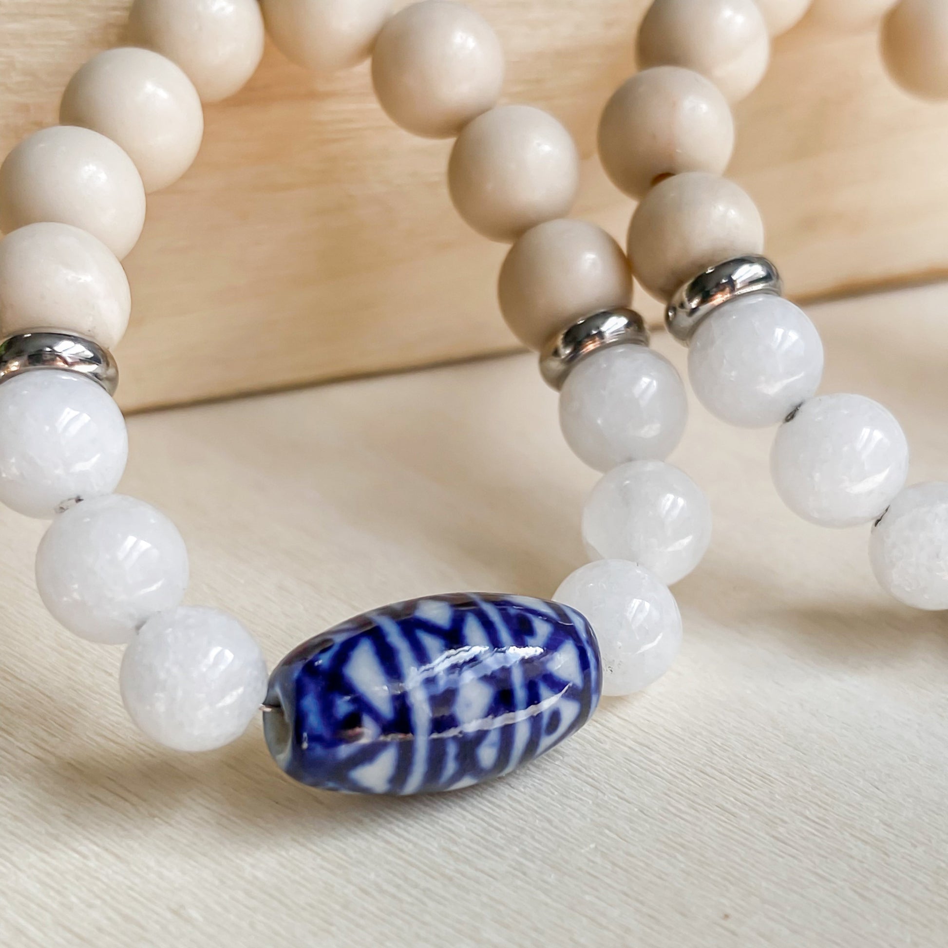 Gros plan sur la perle de céramique bleue artisanale des boucles d’oreilles bohèmes Naxos.