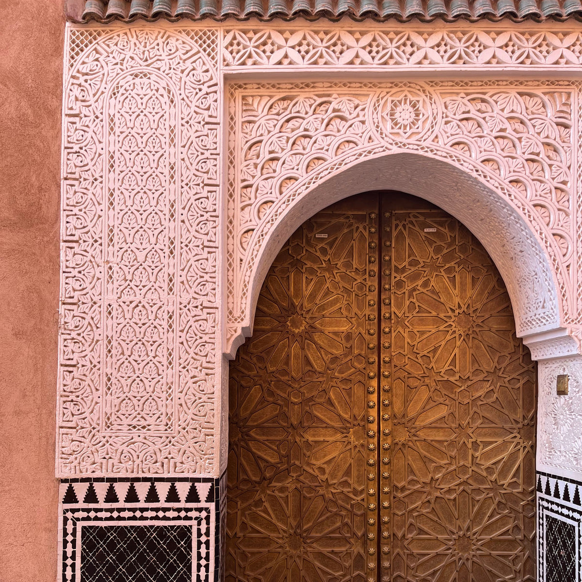 Porte en bois sculpté et mur terracotta au Maroc ayant inspiré le bracelet Terra