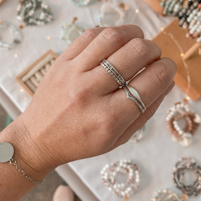 Bague Moonphase en Argent Sterling 925 portée sur le majeur en combinaison avec les bagues Pico, Flow et Eden, mettant en valeur les phases lunaires en relief et les zircons, pour un look élégant et mystique.