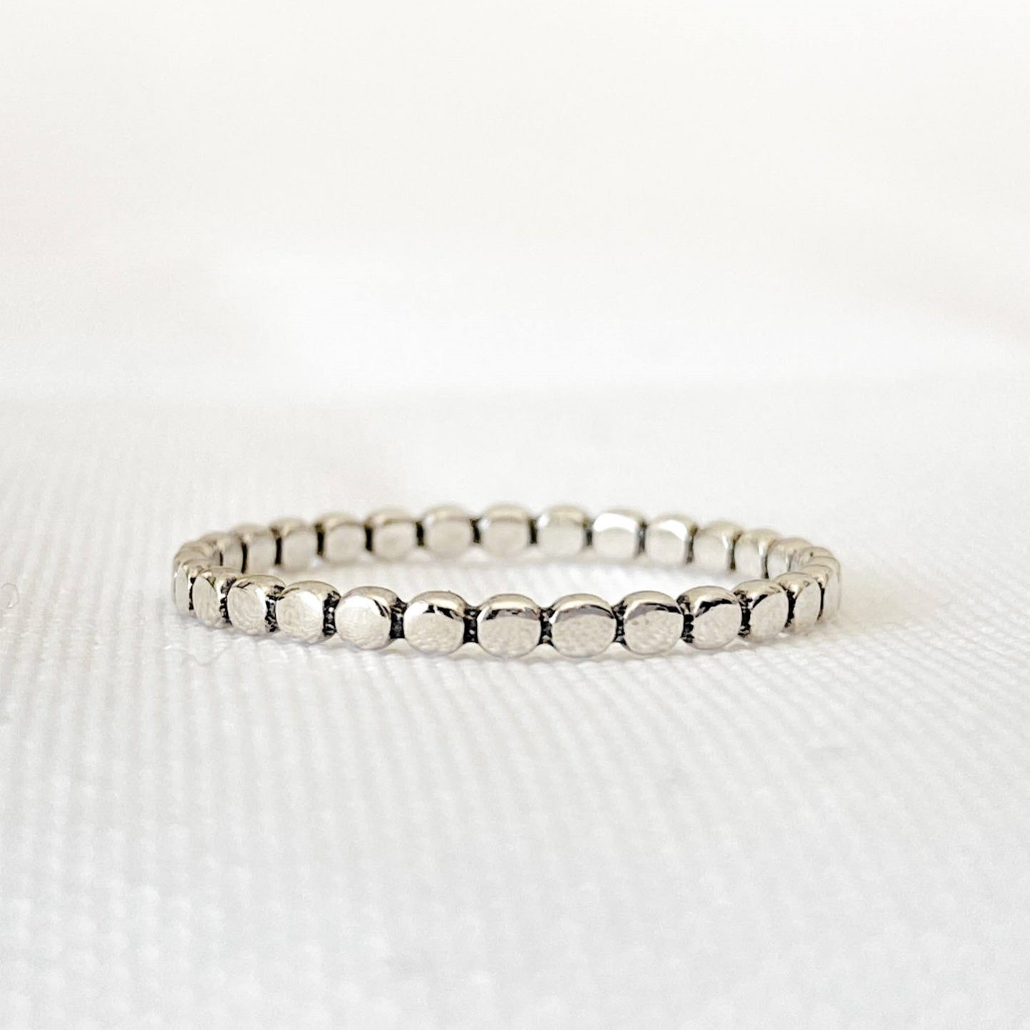 Bague Pico en argent sterling 925 vue de face sur fond blanc, avec un anneau pointillé uniforme, alliant élégance discrète et originalité. Parfaite pour un look simple et raffiné, durable et résistante.