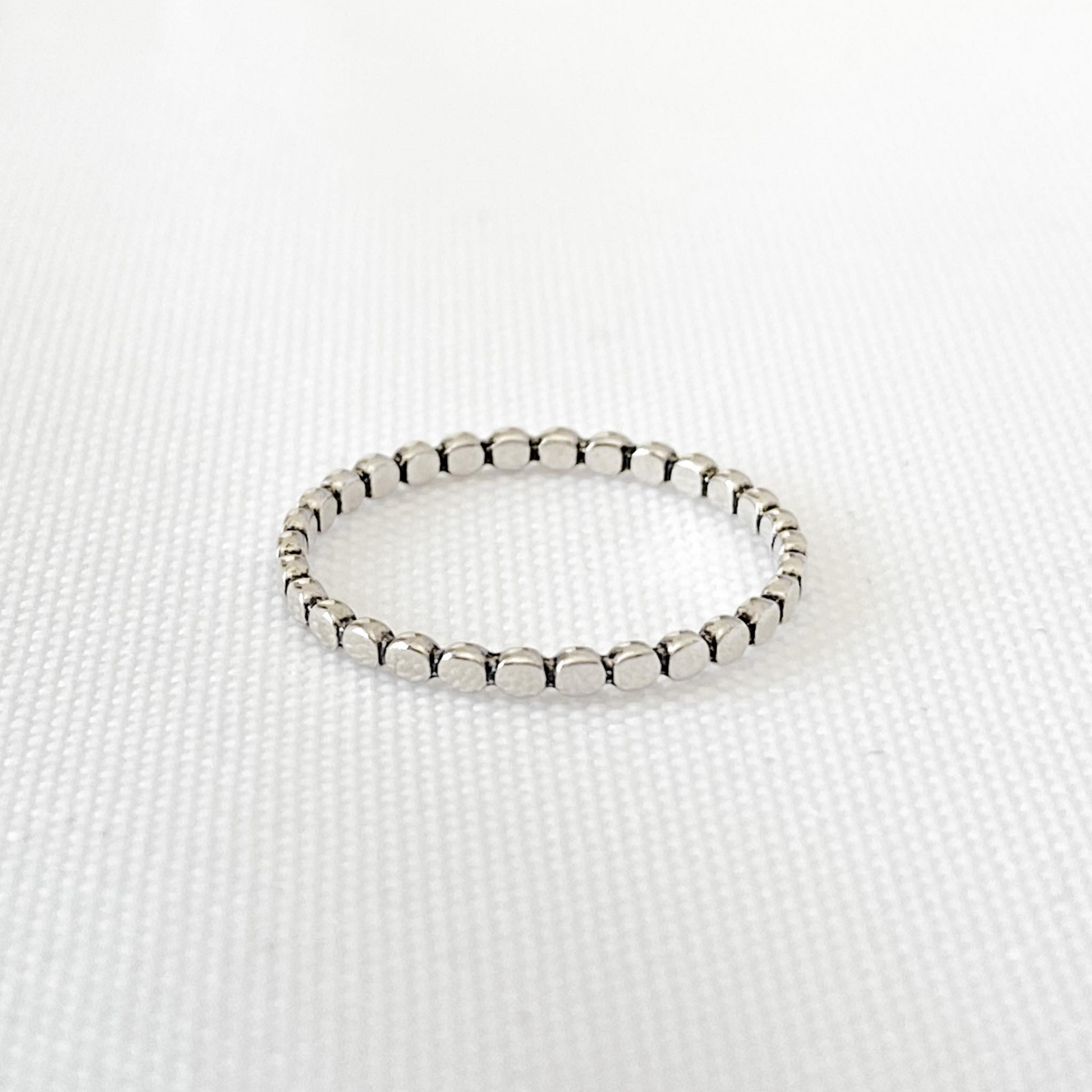 Vue de haut de la bague Pico en argent sterling 925, avec son anneau pointillé uniforme, offrant une texture unique et une simplicité raffinée, idéale pour un look élégant et intemporel.